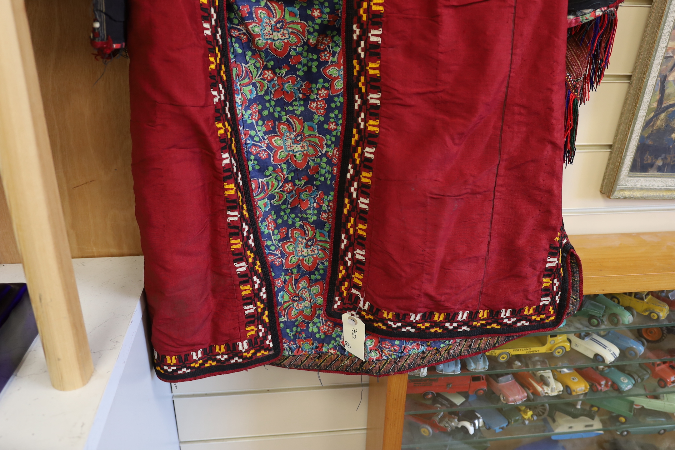 A Tekke Turkoman woman's red ground robe (khalat), the collar embroidered with red, gold and white devices, together with a red triangular shawl, longest side (2)